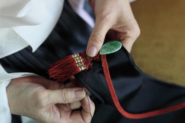 손바느질로 한복을 만들고 있는 모습(조바위의 장식대기). [문화재청 제공]